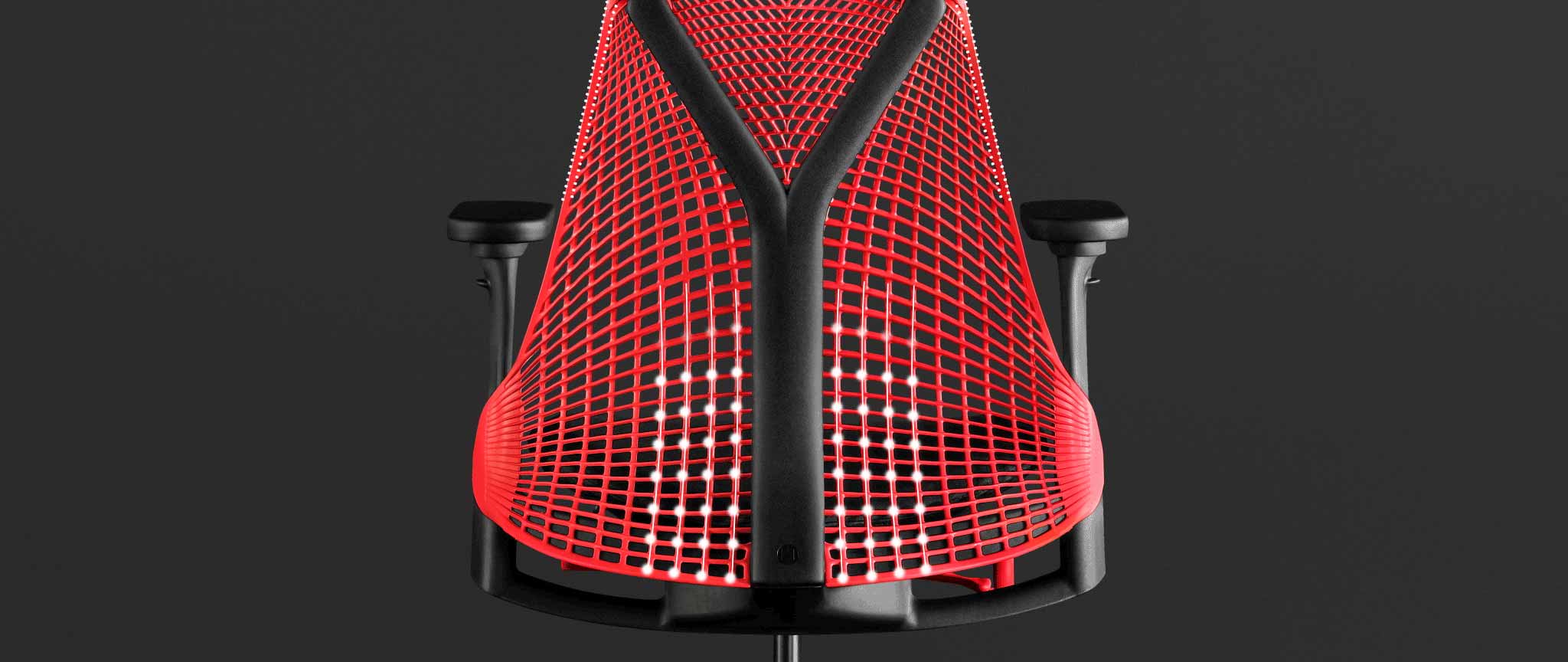 Rückansicht eines rot-schwarzen Sayl-Gaming-Stuhls von Herman Miller, überlagert von weißen Grafiken, die die gefederte Rückenlehne hervorheben.
