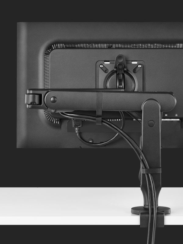 Rückansicht eines schwarzen Ollin-Gaming-Monitorarms von Herman Miller, die das Kabelmanagement zeigt.