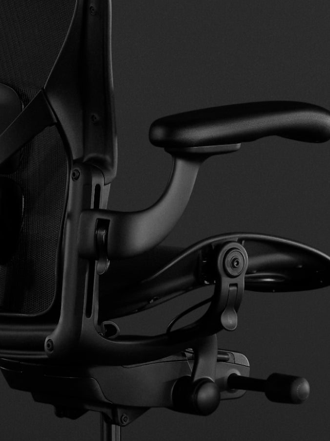 Seitenansicht eines schwarzen Aeron-Gaming-Stuhls von Herman Miller, mit Blick auf die Neigungsfunktion.