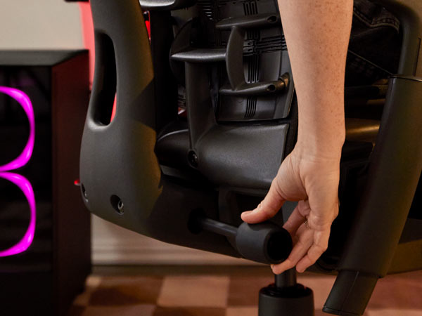 Nahaufnahme von Dr. Lindsey Migliore, die den Rücken des Embody-Gaming-Stuhls einstellt