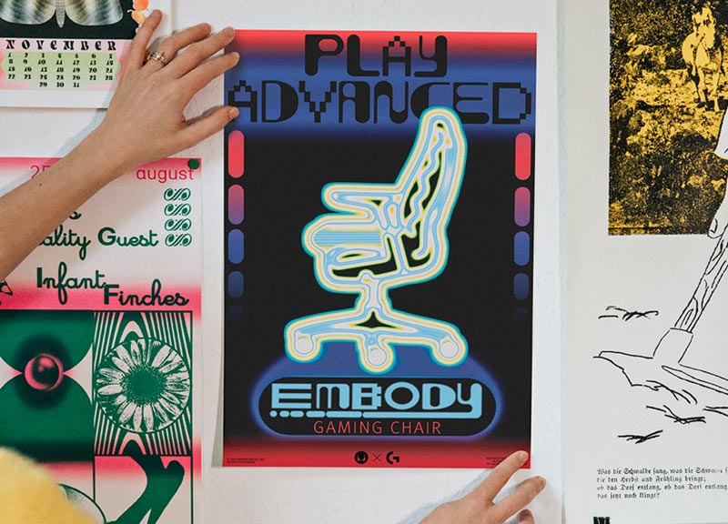 Bild des endgültigen Posters für den Embody-Gaming-Stuhl, das von Molly Rose Dyson an die Wand gehalten wird