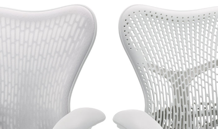 Zwei weiße Mirra 2-Bürostühle von Herman Miller, nebeneinander aufgestellt. Hier sind die beiden Rückenlehnenvarianten zu sehen, eine mit und eine ohne zusätzliche Stoffschicht.