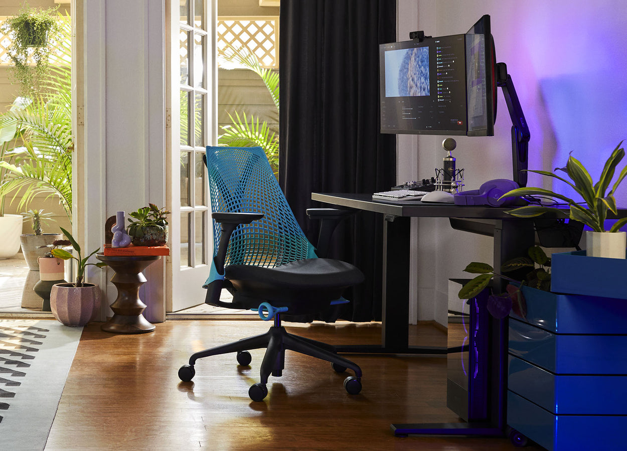 Foto von Friskks Gaming-Setup zu Hause, bestehend aus einem schwarzen Gaming-Stuhl Sayl in Ozeanblau und einem schwarzen Gaming-Tisch Nevi.