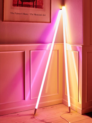 Zwei HAY Neon-LED-Röhren in Pink und Orange, an eine weiße Wand gelehnt.