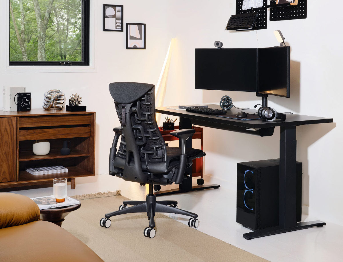Herman Miller schwarzer Embody Gaming-Stuhl mit schwarzem Nevi Sitz-Steh-Gaming-Tisch mit Gaming-Setup inklusive zwei Monitoren