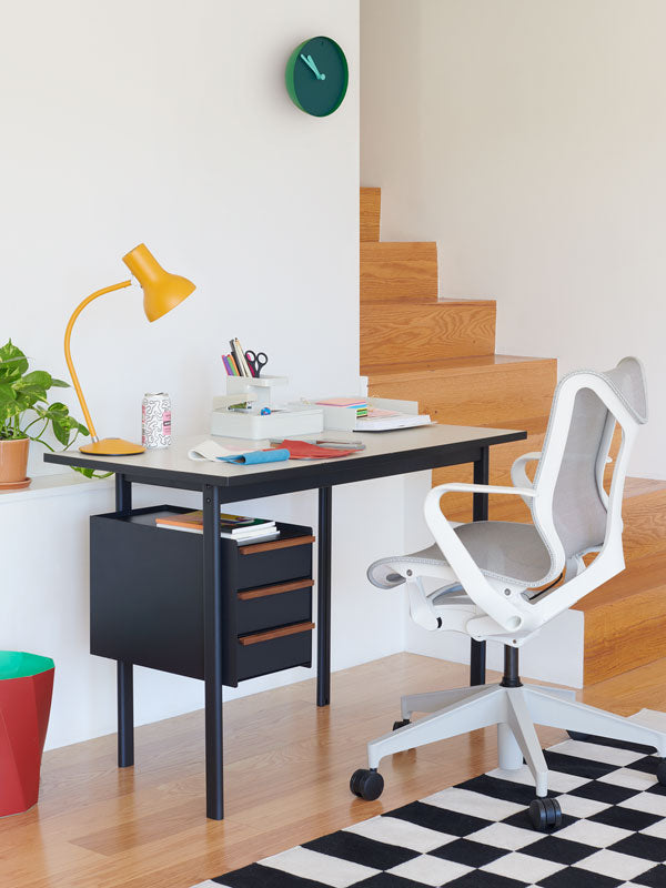 Home Office mit Mode-Schreibtisch mit fester Höhe und Schubladenablage und weißem Cosm-Bürostuhl mit niedriger Rückenlehne und diversem Bürozubehör.