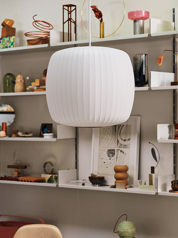 Nahaufnahme der Roll Nelson Bubble Deckenleuchte, die vor Regalen mit ikonischen Ornamenten hängt.