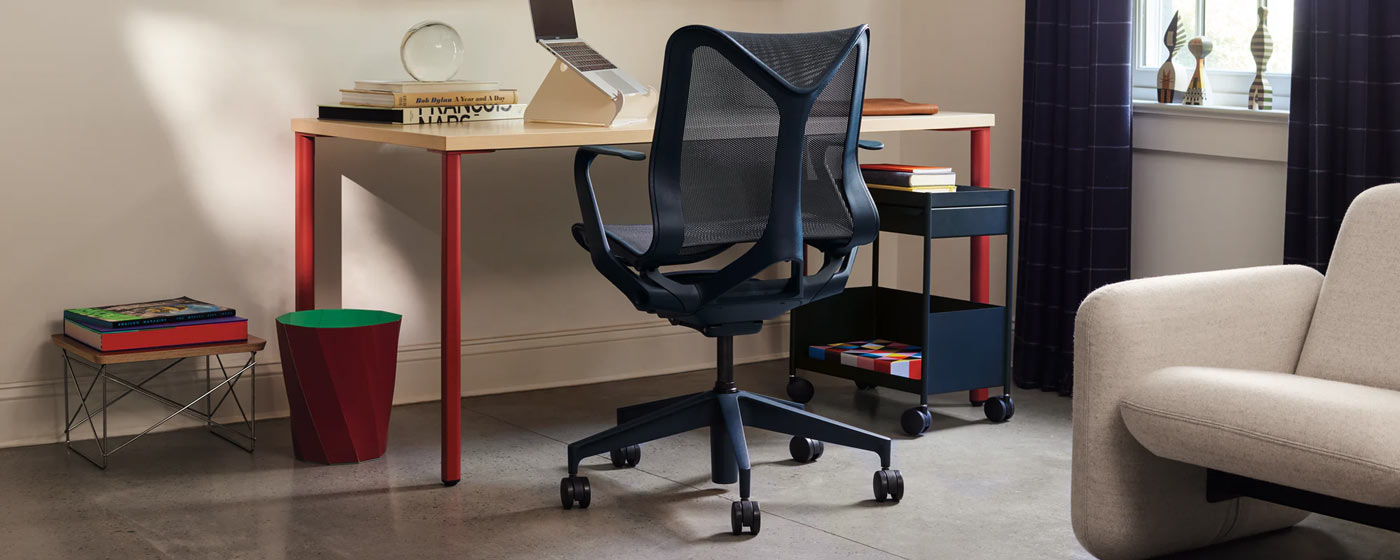 An AbakEnvironments Desk with a walnut top and polished legs, with a graphite Aeron Chair in a light home office setting and Folk Ladder Shelving.