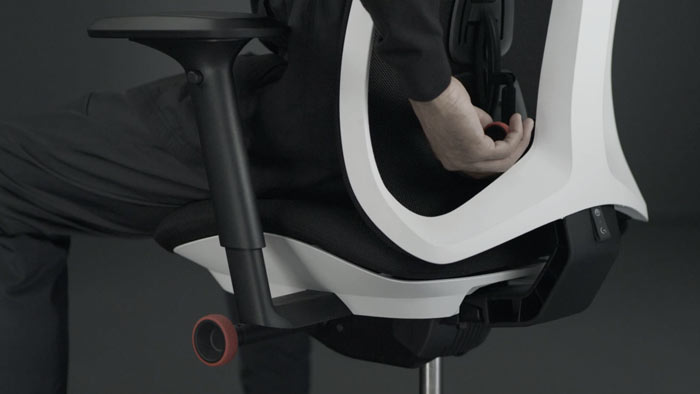 Video einer Person, die in einem weiß-schwarzen Vantum-Gaming-Stuhl von Herman Miller sitzt und hinter den Stuhl greift, um die Rückenlehne zu verstellen.