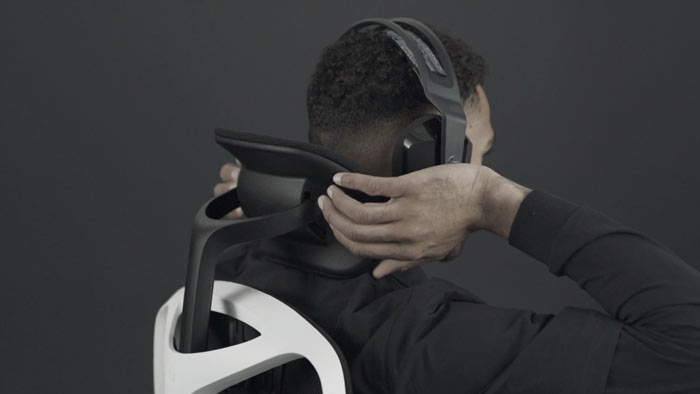 Ein Video von einer Person, die in einem weiß-schwarzen Vantum-Gaming-Stuhl von Herman Miller sitzt und hinter den Stuhl greift, um die Kopfstütze zu verstellen.