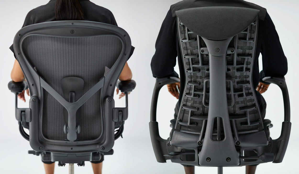 Nahaufnahme von hinten von Personen, die aufrecht auf einem Aeron-Bürostuhl in Graphit und einem Embody-Bürostuhl in Schwarz sitzen