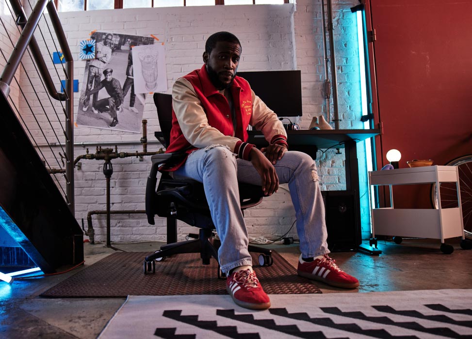 Bild von Deansocool vom G2 Esports-Team, sitzend auf einem G2 Embody-Stuhl, mit dem Gaming-Setup im Hintergrund, darunter ein schwarzer Nevi-Gaming-Tisch mit Ollin-Monitoren