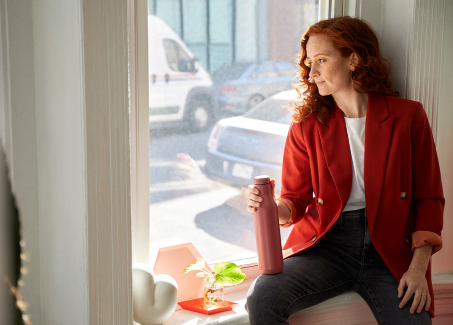 Foto von Dr. Lindsey Migliore, die eine Pause macht und auf der Fensterbank sitzt und aus dem Fenster schaut