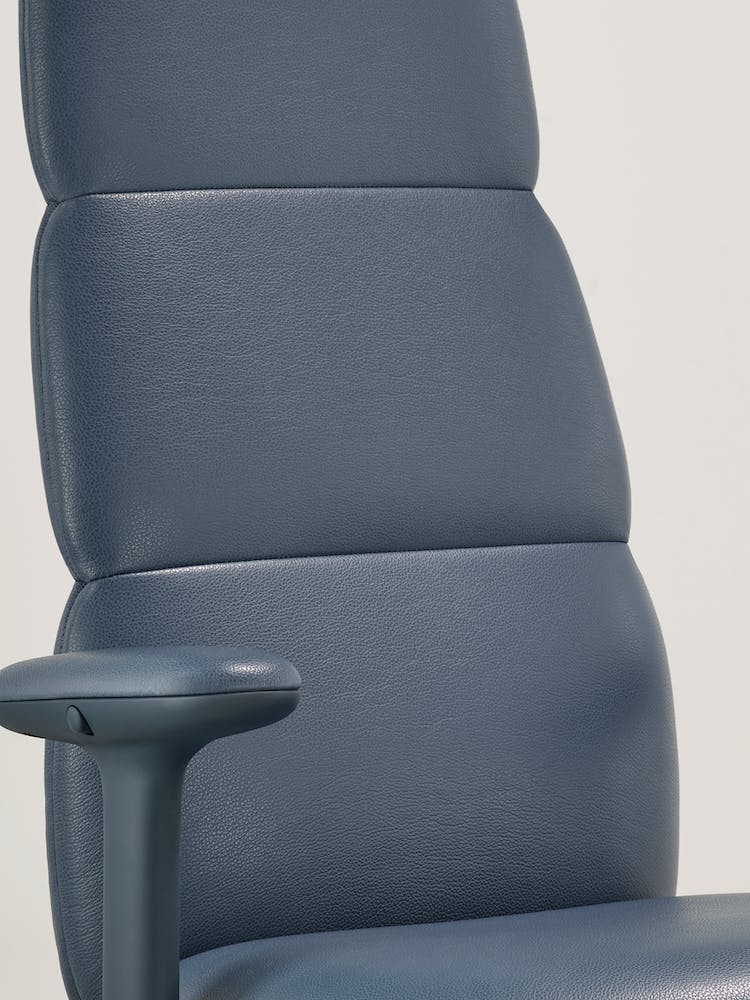 Nahaufnahme eines blauen Asari-Bürostuhls aus Leder von Herman Miller, der die integrierte, interne Posturefit-Technologie zeigt.