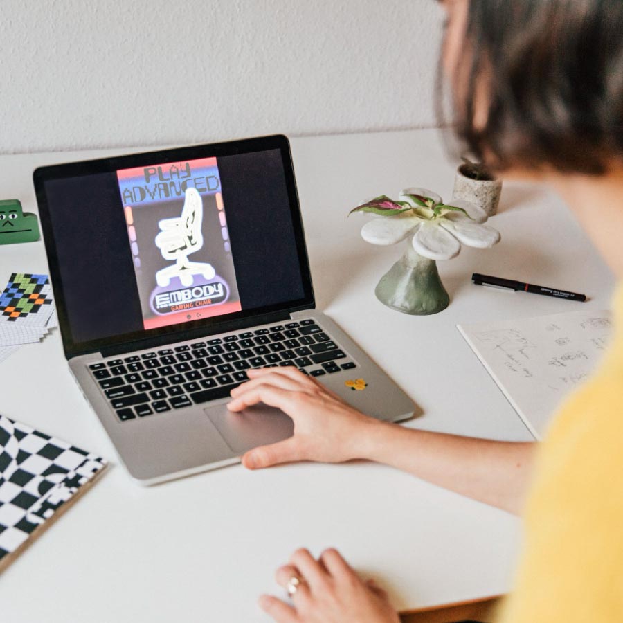 Die Designerin Molly Rose Dyson arbeitet an einem Herman Miller Embody-Poster auf einem Laptop