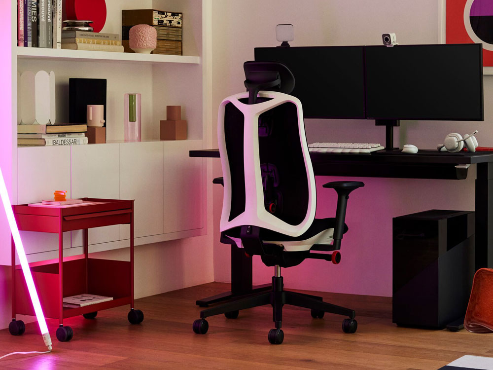 Ein Logitech x Herman Miller Vantum Gaming-Stuhl in Weiß als Teil eines Gaming-Setups. Mit Nevi-Schreibtisch, Ollin-Monitorarm, OE1-Trolley und einer HAY-Neon-LED-Röhre.