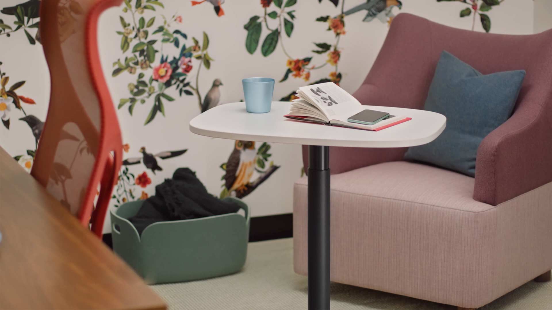 Ein Video einer Frau, die in einem gelben Wilkes-Sessel sitzt und einen Passport-Tisch von Herman Miller benutzt. Das Video zeigt, wie der Passport-Tisch an verschiedenen Orten verwendet wird, sowohl in Büros als auch zu Hause.