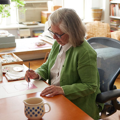 Illustratorin, Malerin und Autorin sitzt malend in einem Herman Miller Aeron-Bürostuhl in Graphit