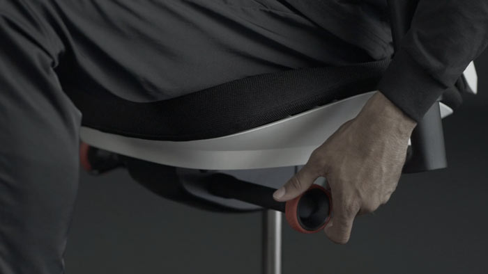Ein Video von einer Person, die in einem weißen und schwarzen Vantum-Gaming-Stuhl von Herman Miller sitzt und neben den Stuhl greift, um den Neigungsbegrenzer einzustellen.