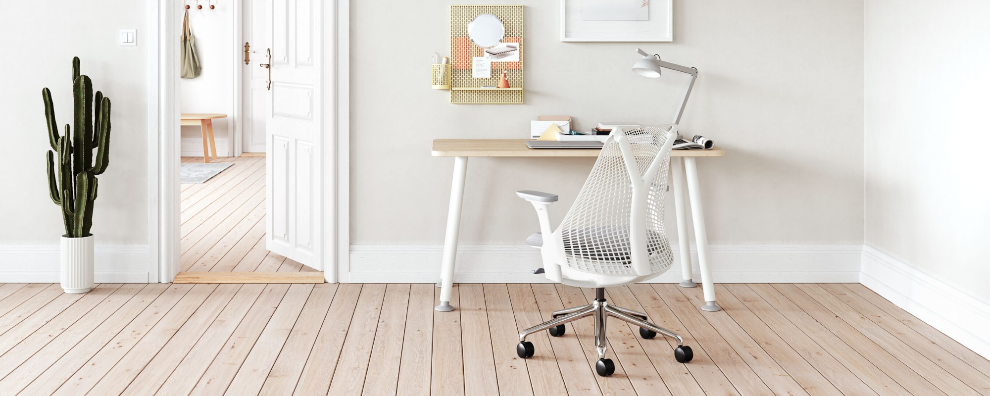 A light home office environment featuring a White Sayl Chair with polished base at a Halifax White Oak Memo Desk with a Formwork Paper Tray ontop